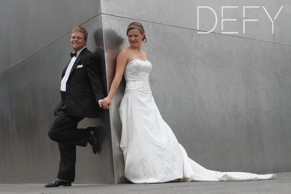 bride and groom leaning against the arch