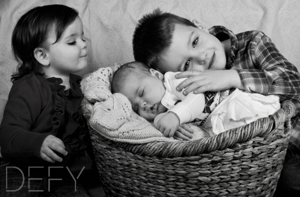 big brother and sister loving new baby