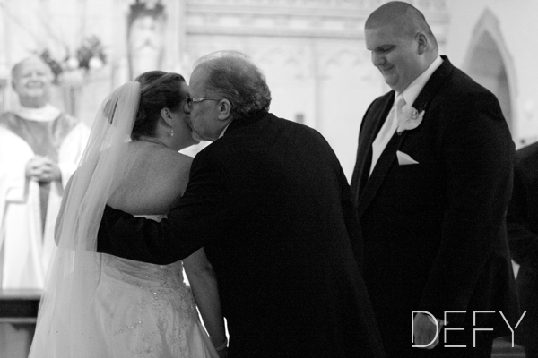 Father giving bride kiss